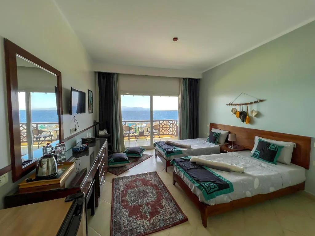 An original Club Red twin room, with the Red Sea visible through its balcony doors.